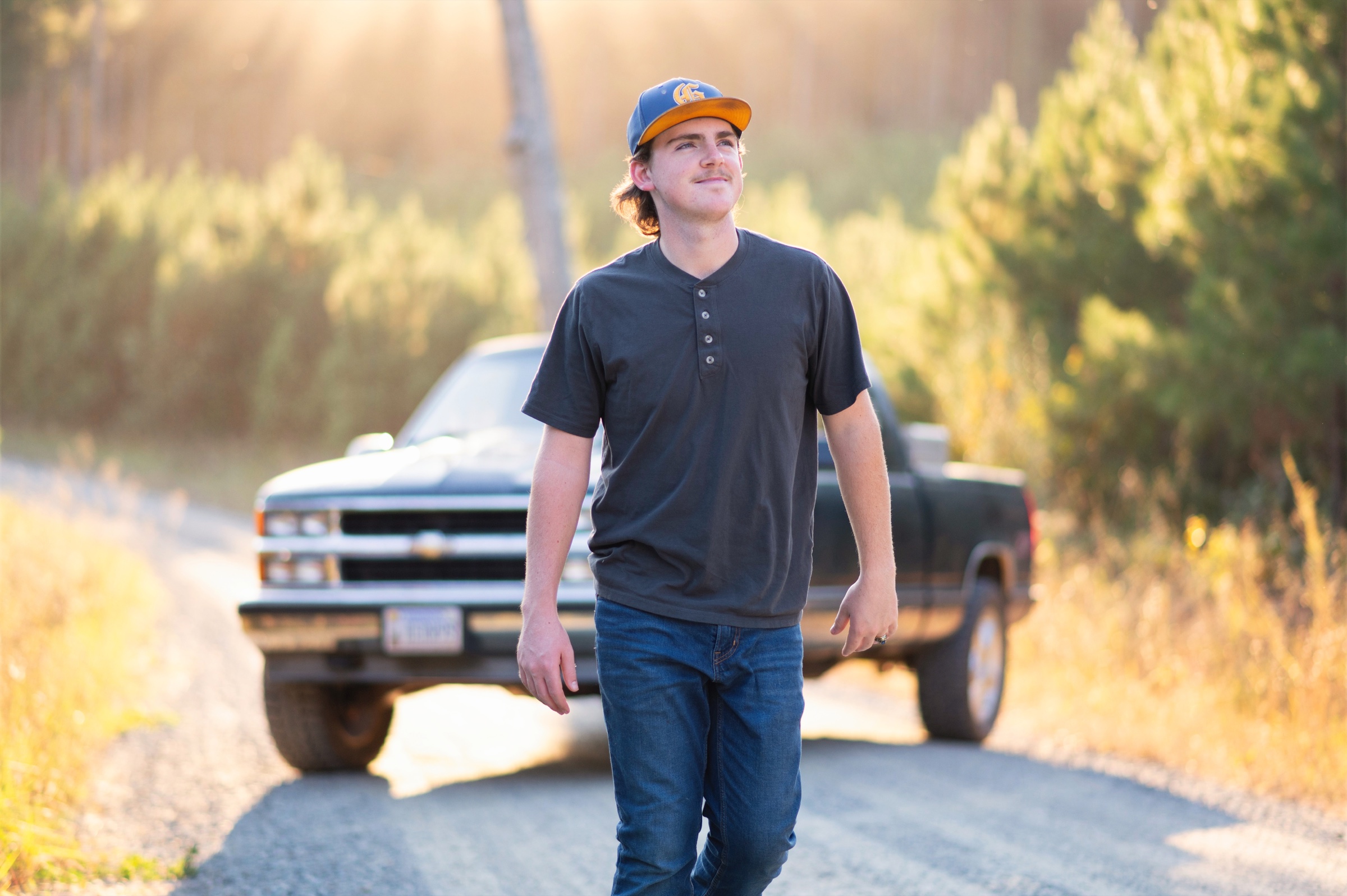 Senior boy portrait with a vintage truck on a country road